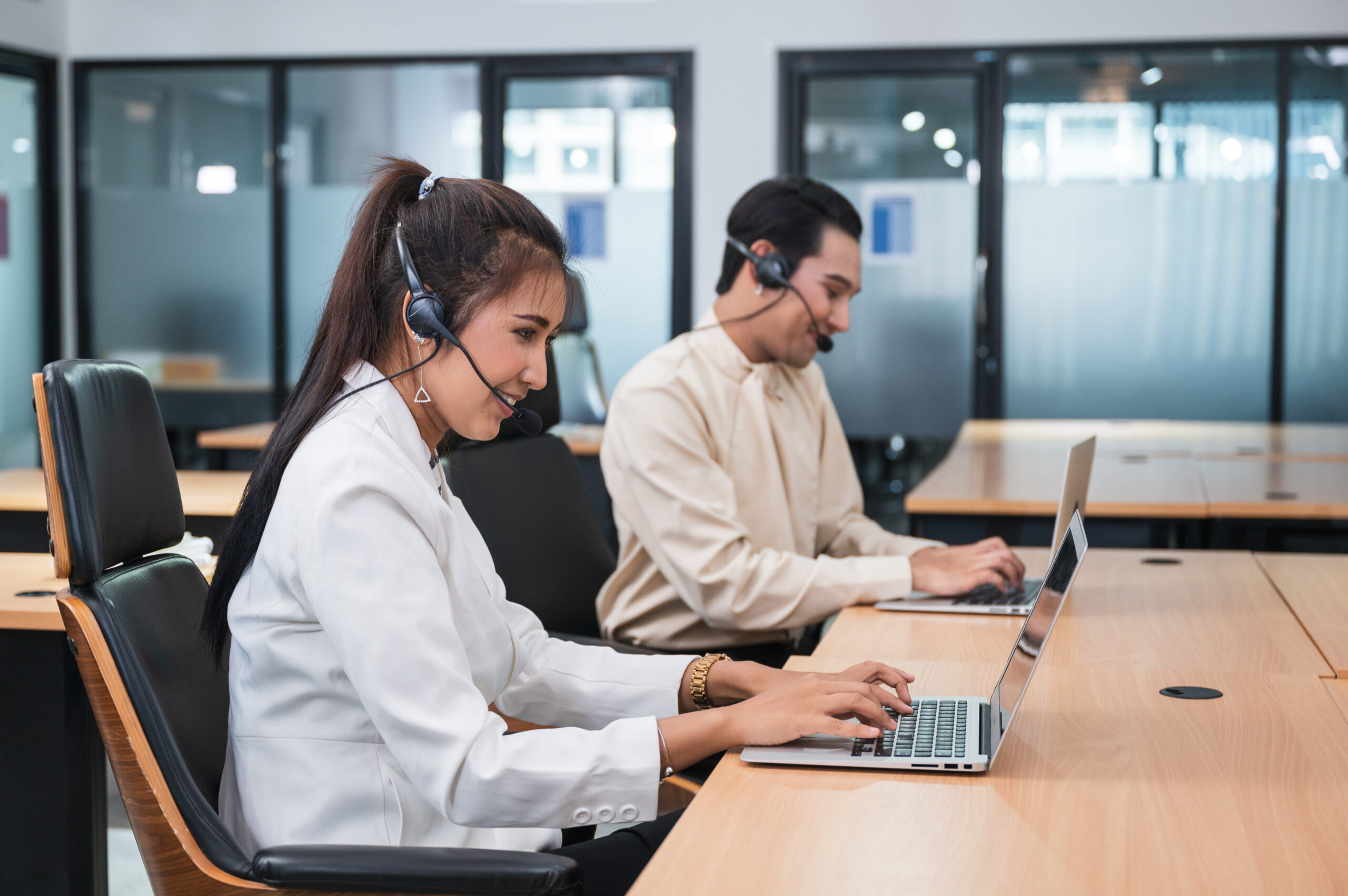 Operator asian woman agent with headset working with laptop on c