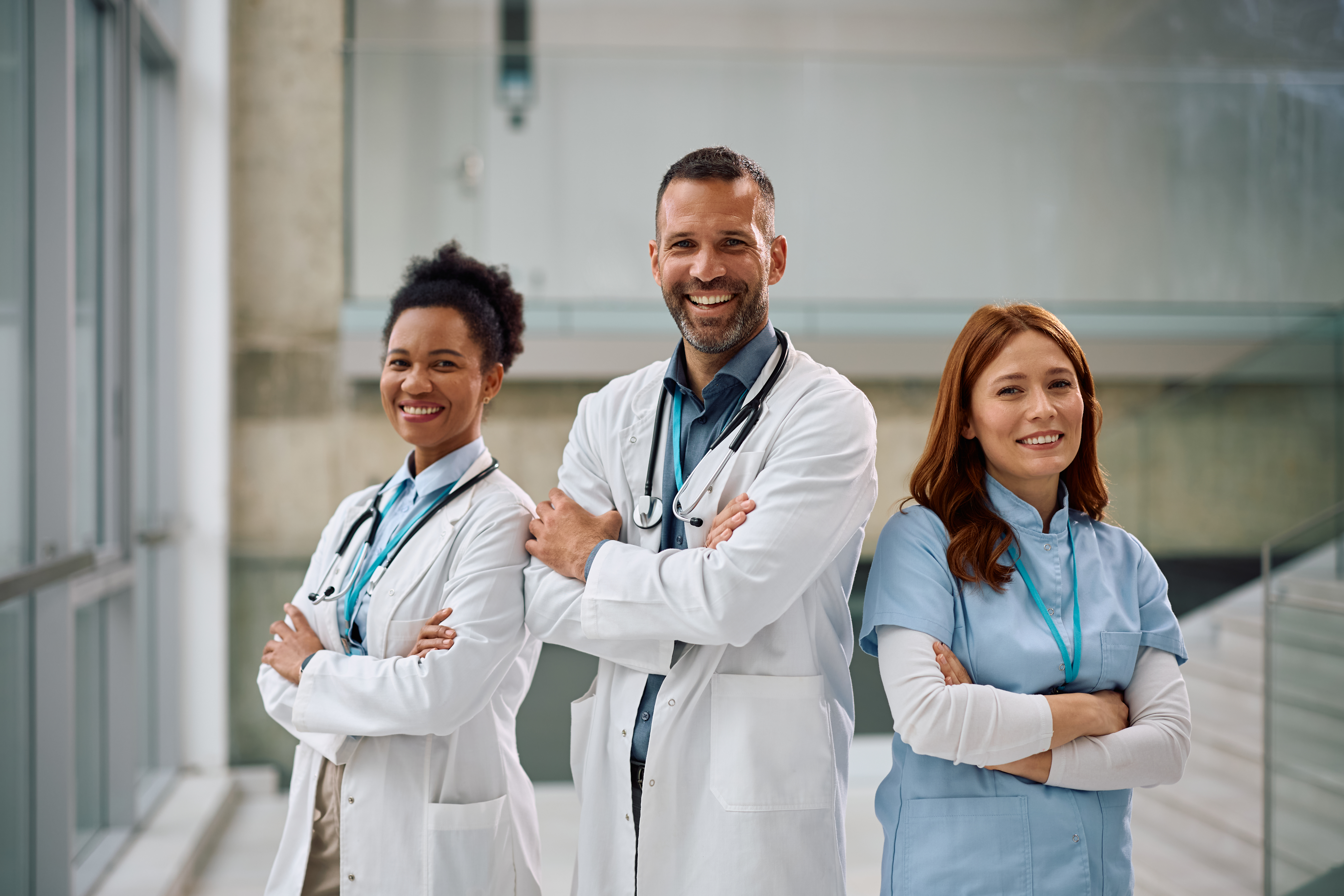 Team of confident healthcare workers at medical clinic looking at camera.